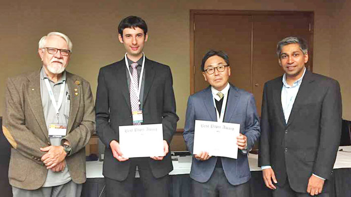 Prof. Akira Chiba (centre right) and researcher Jacob Bayless (center left) with IEEE officials.