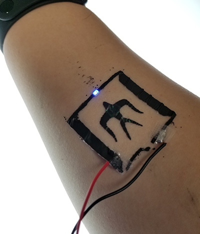 Electricity is applied to a polymeric thin film with a circuit, illuminating a specific location. The circuit was screen-printed using commercially available carbon ink.