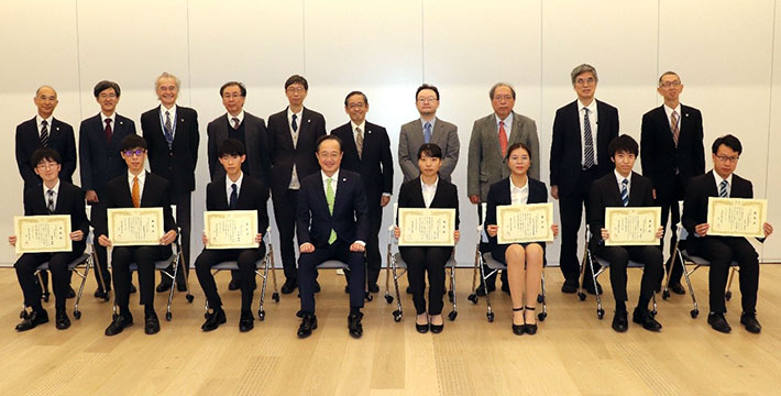 授与式後の記念撮影（前列左から、吉田さん、コーンヴィクさん、伊藤さん、益学長、松永さん、ディンさん、奥山さん、石沢さん）
