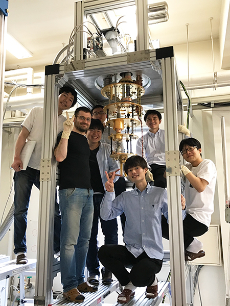 研究室メンバーと極低温冷凍機を立ち上げる小寺准教授（装置右奥）。2019年7月撮影。