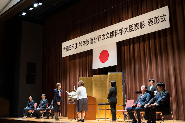 文部科学省講堂で行われた表彰式で賞状を受け取る波多野教授