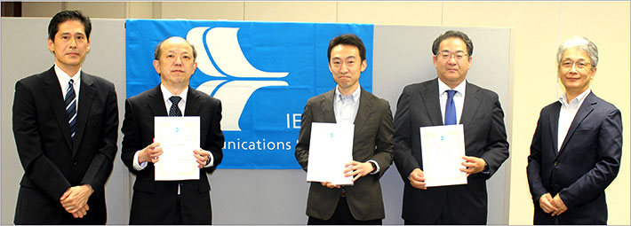 From left: Dr. Sanada (President of the 2025 IEICE Communications Society), Dr. Hirokawa (Professor), Dr. Tomura (Associate Professor), Dr. Watanabe (NICT), and Dr. Takahashi (Editor-in-Chief of the 2025 IEICE Communications Society)