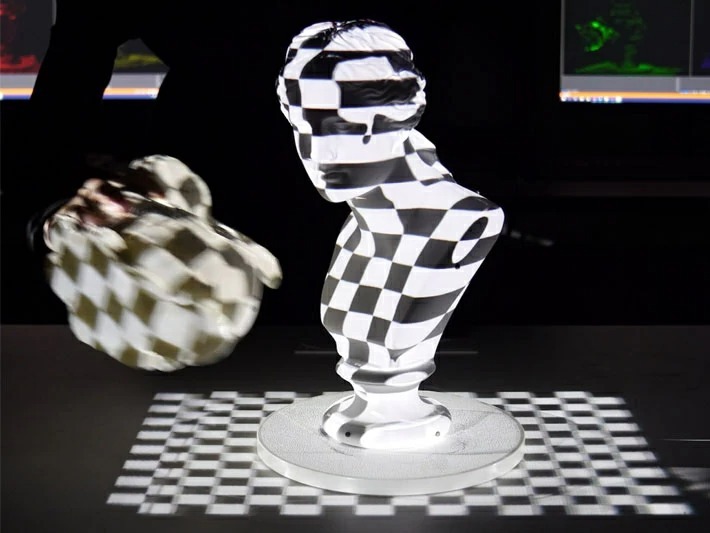 Comparison of projection mapping results using a single projector and a multi-projector system - A newly developed multi-projector system consisting of four units can eliminate shadows even in dynamic scenes.
