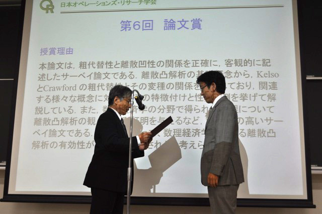 日本オペレーションズ・リサーチ学会で受賞する塩浦准教授（右）