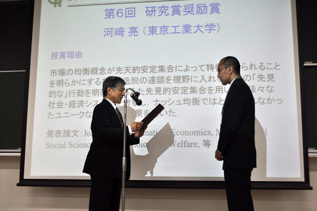 日本オペレーションズ・リサーチ学会で受賞する河﨑准教授（右）