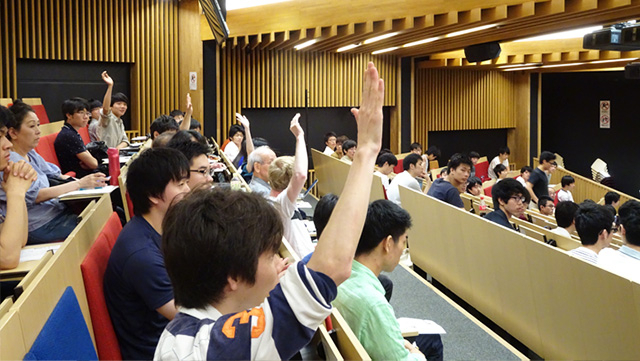 質問のために一斉に手を挙げる参加者たち
