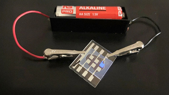 図1.乾電池(1.5 V)1本で深青色有機ELを光らせている写真