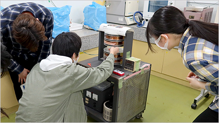 Participant extracting magnetized ferrite sample from magnetization apparatus