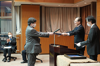 益学長から表彰される桑原さん（左）